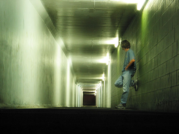 A young guy leaning against the wall of undercrossing, Auckland, New Zealand