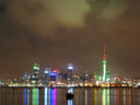 Auckland city by night, reflections in Waitemata Harbour, green and red Sky Tower
