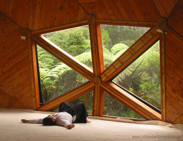 Aikidoka resting by the unusual shaped window facing fern bush, Coromandel, New Zealand