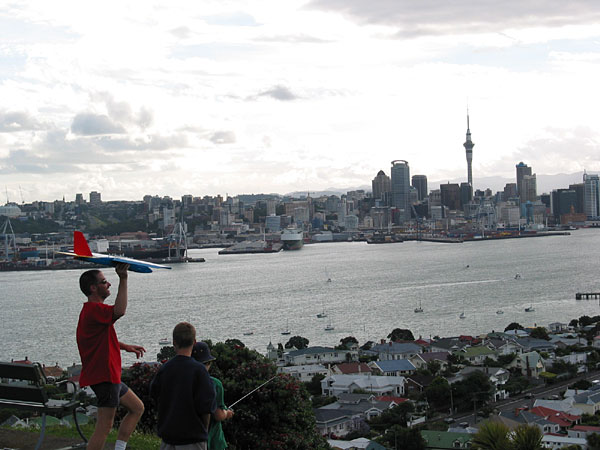 Dad with kids launching a radio controlled airplane from Mt Victoria in Devonport, Devonport, Auckland, New Zealand