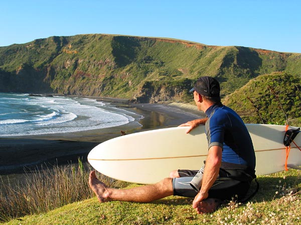 Flat swell, no fun for surfer, Te Henga Beach, Auckland, New Zealand