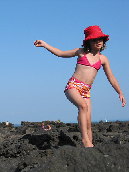 Little girl walking volcanic rocks, Auckland, New Zealand